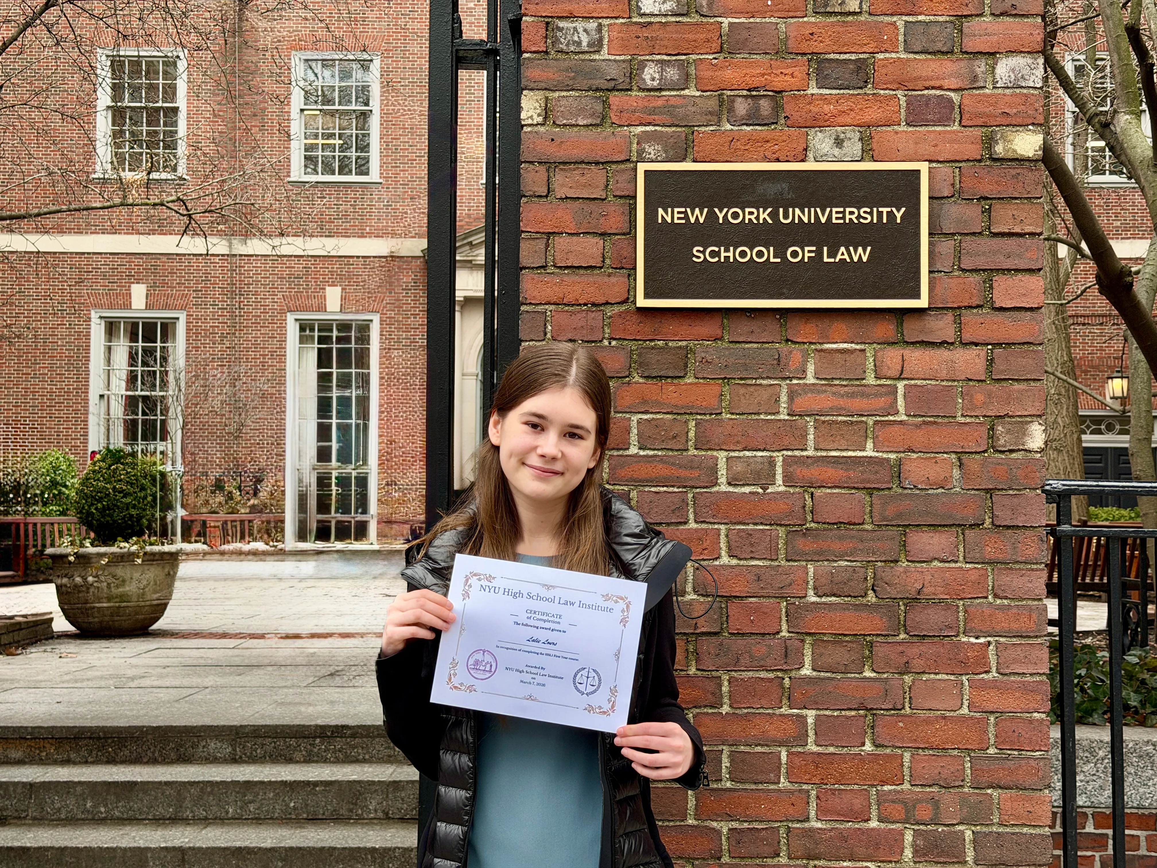 Lalie Lours (Best Teen Book Review Site) photo with NYU HSLI certificate outside the new york university law building for her NYU high-school law institute program